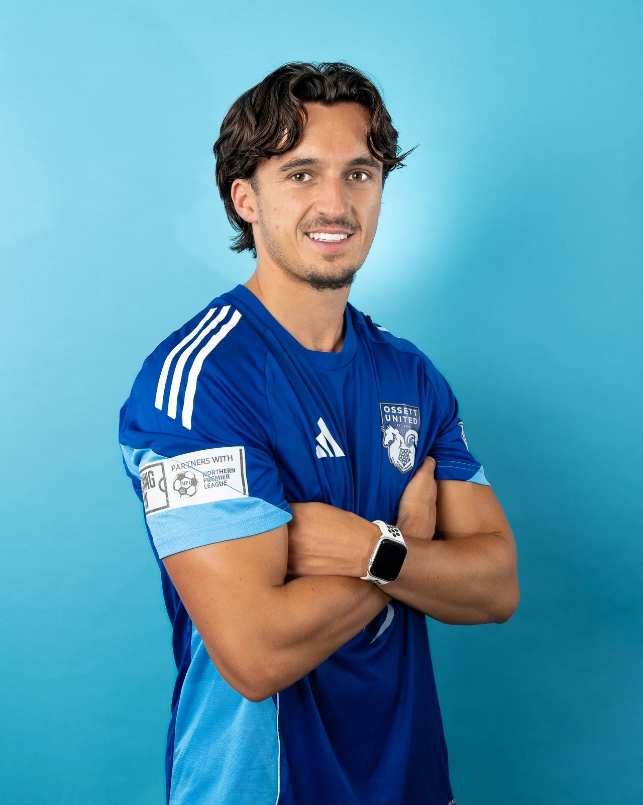 Smiling player photographed against a light blue studio background.